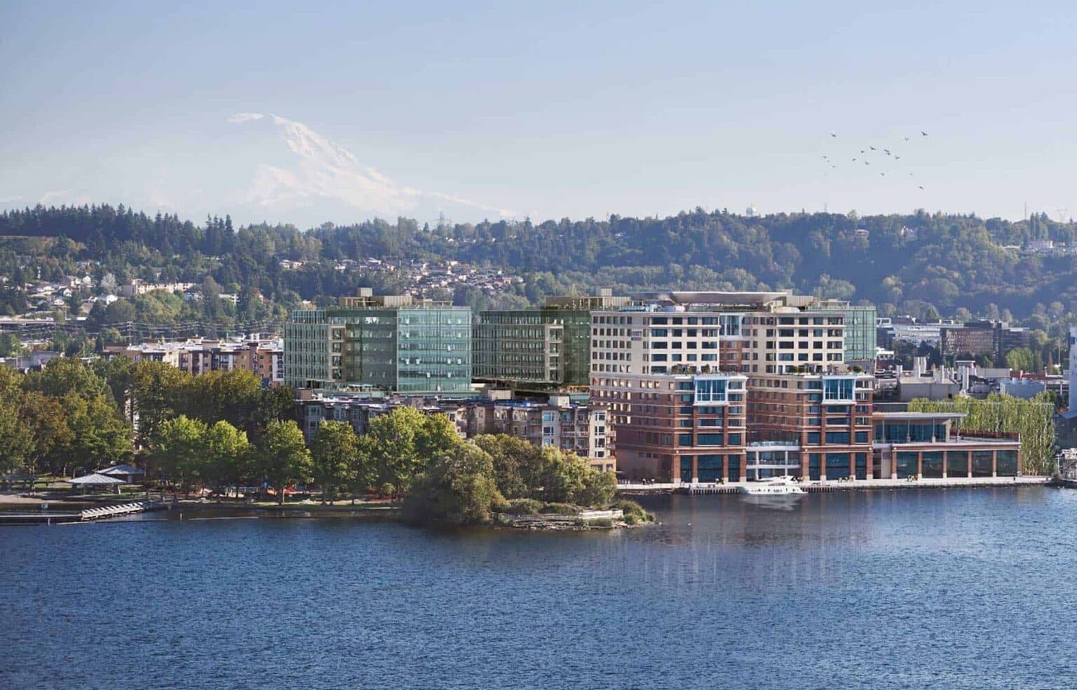Aerial view of Renton, Washington, showing a mix of forested areas, suburban neighborhoods, and roads with Mount Rainier visible in the background under a clear blue sky.