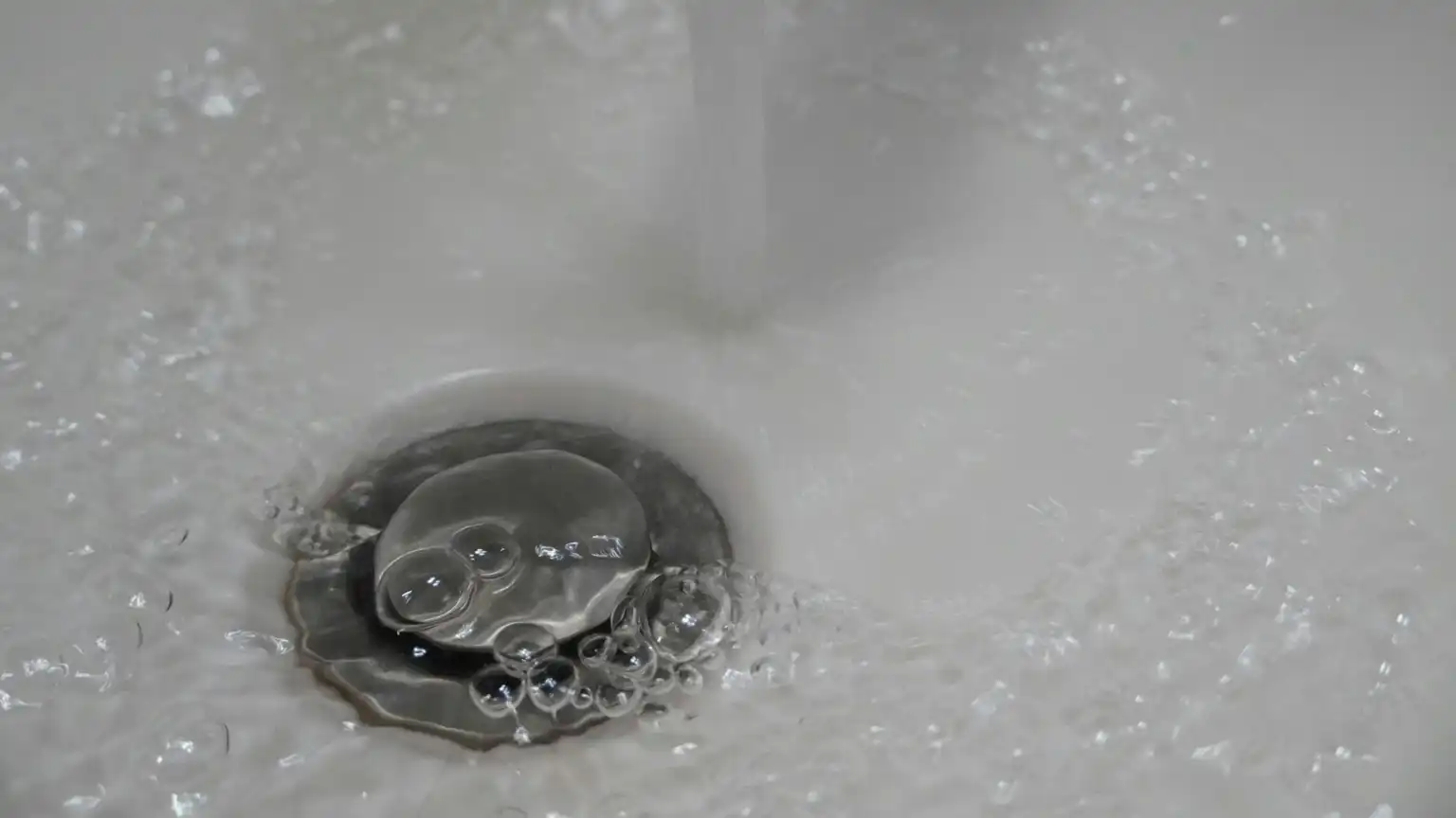 a close up of a sink with water running down it